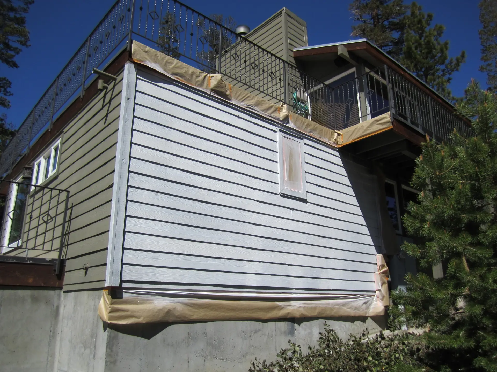 Home exterior with siding masked off and ready for paint